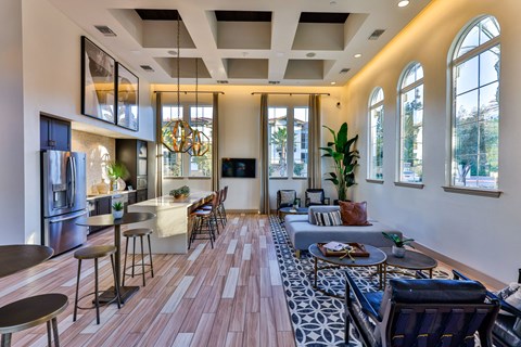 a living room with a couch and chairs and a kitchen